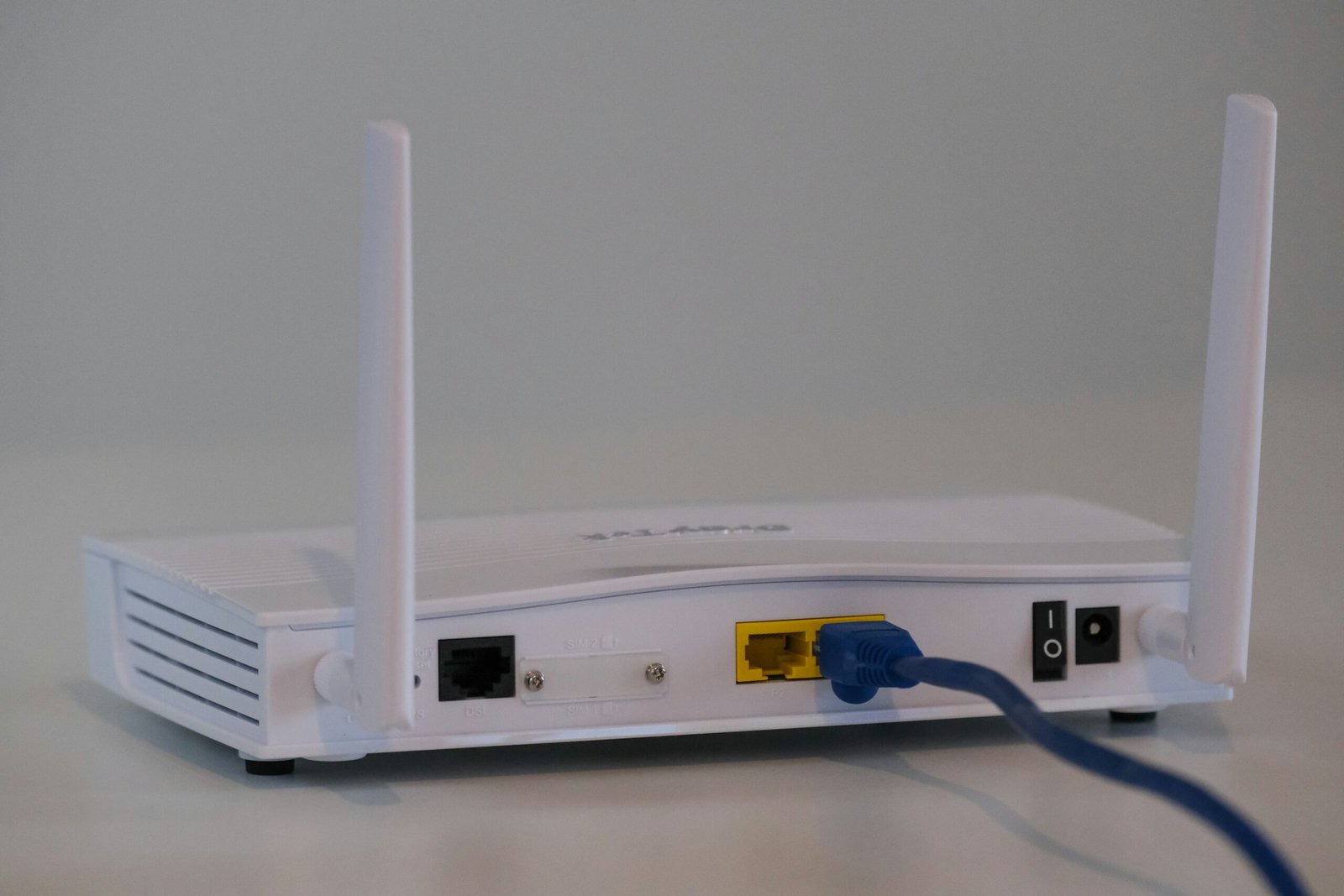 Router wifi blanco con antenas y cables conectados